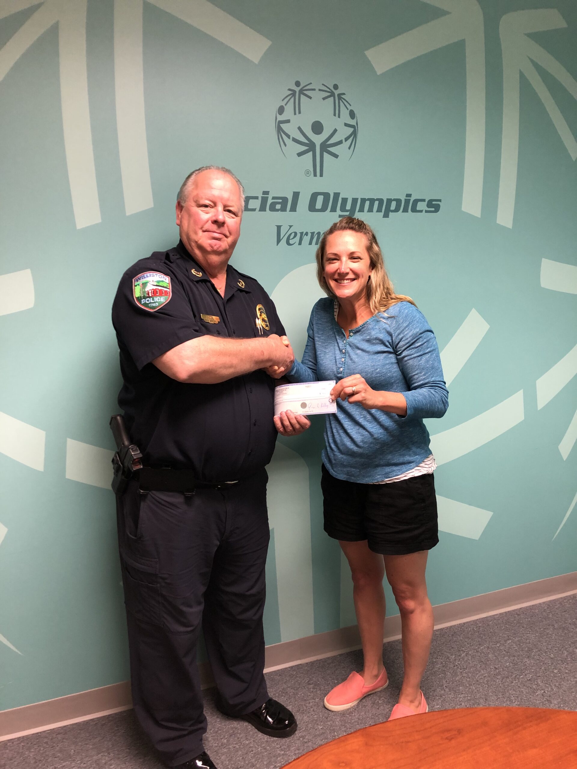 Police chief presenting donation check to woman