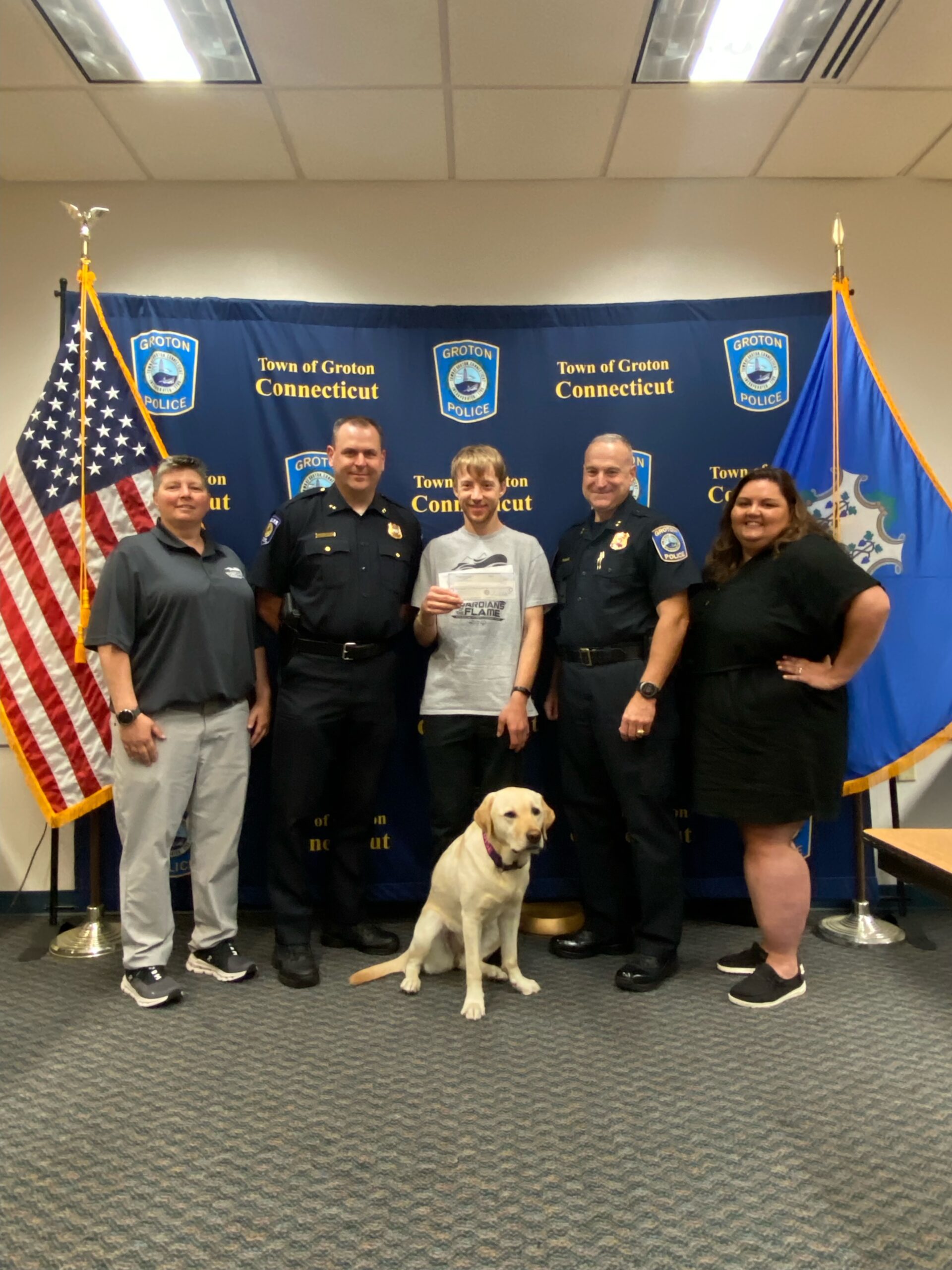 two police ifficers in a group with a dog