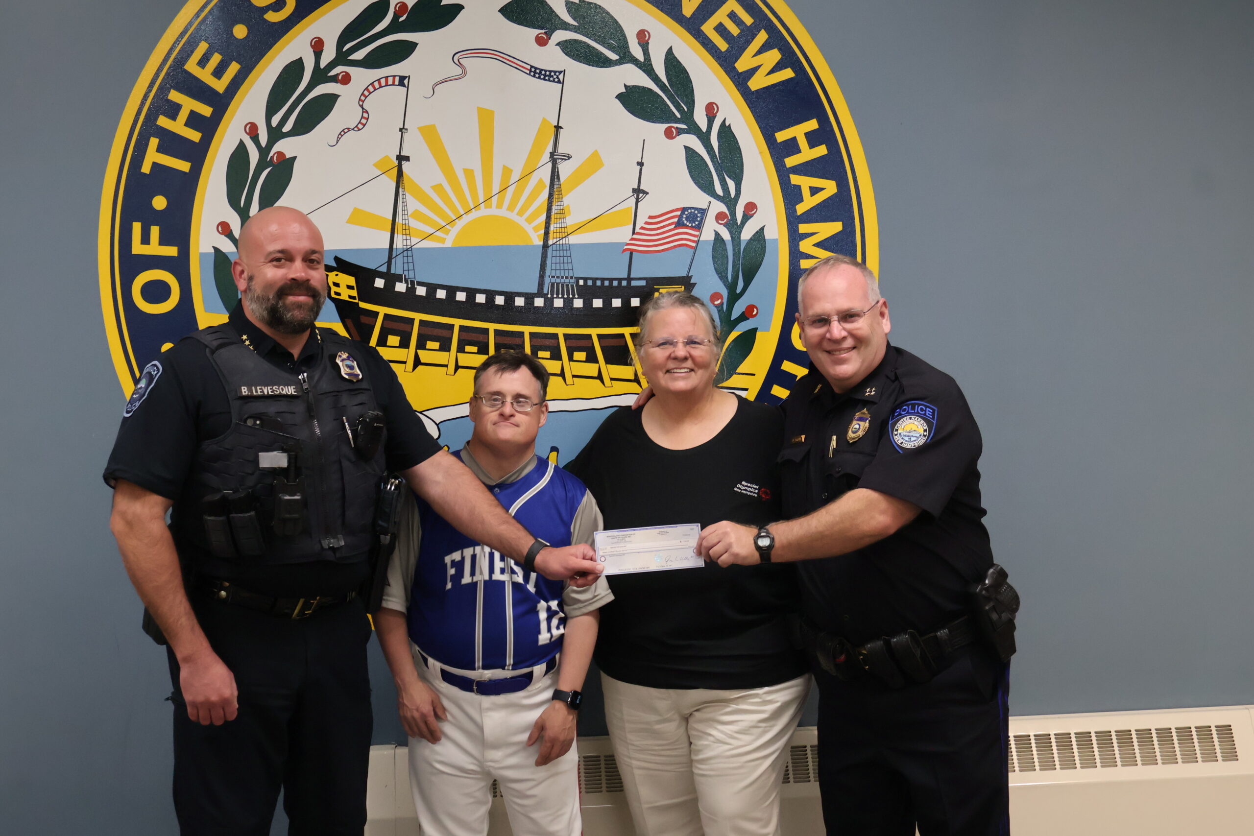 two police officers presenting a check to Special Olympics representatives