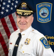 chief of police smiling in hat and uniform shirt with badge