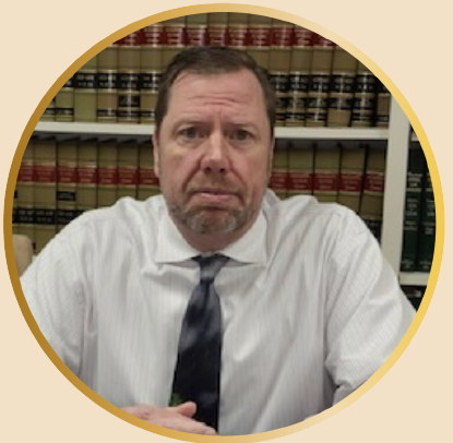 2025.NEACOP-DunlopSnip man in business shirt and tie in front of law books on a shelf